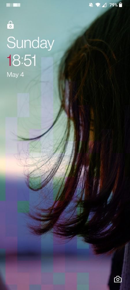 A photo of a woman with here face concealed by hair, only a slim portion of the frame is in focus. it's been edited with blue-ish pixel art that gives the image a gradient.