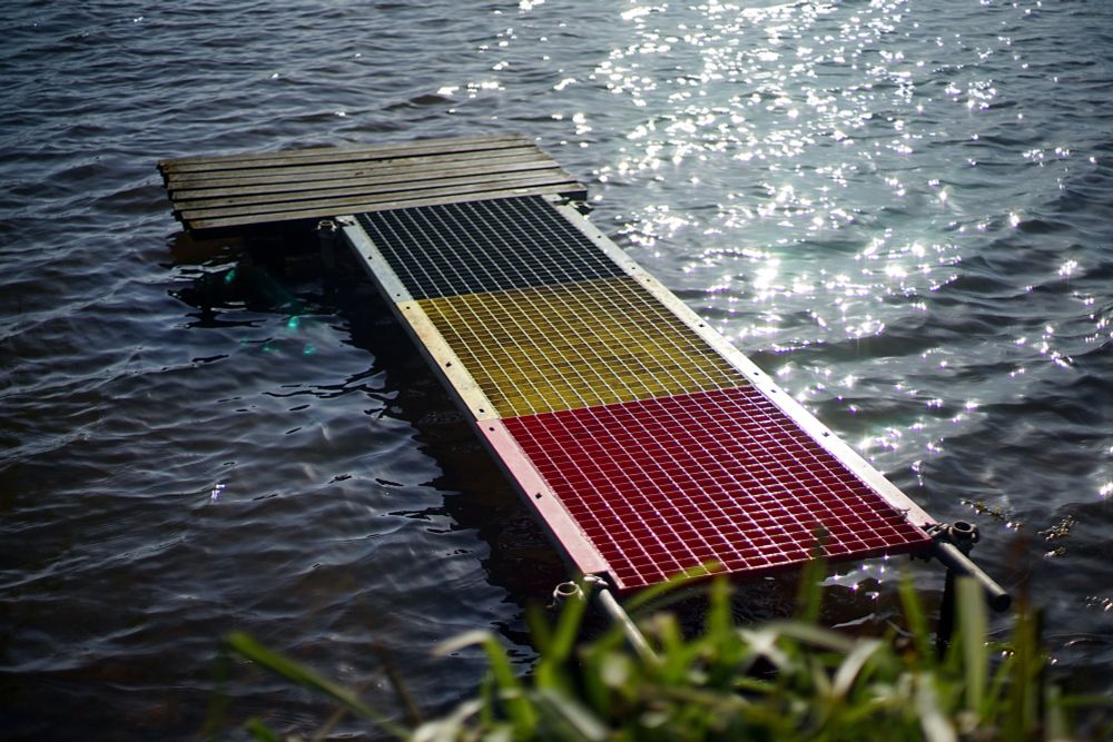 A colourful fishing platform at the edge of a lake. 