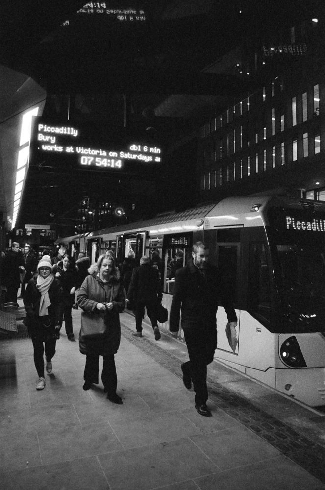 A tram platform with early morning commuters