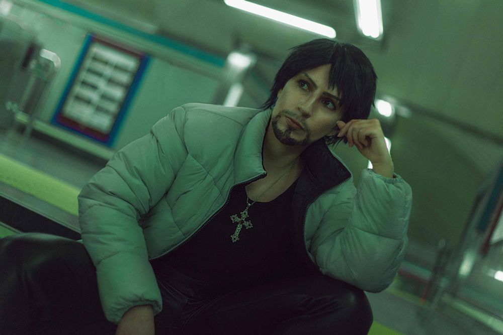 Myself cosplaying as Daigo Dojima from the Yakuza Kiwami 2 videogame. I'm at the subway stairs, sitting while trying to look misterious and cool. It's also edited with the greenish Kiwami filter that you can see in the game! :D