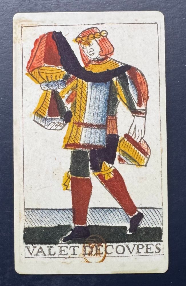 The Page of Cups shows a male figure holding two large cups. Text on the card says Valet De Covpes. Card from the Noblet Tarot