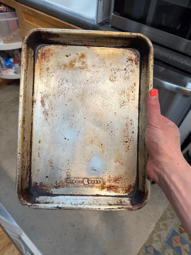 An aluminum 1/4 sheet pan with a lot of polymerized oils on it 