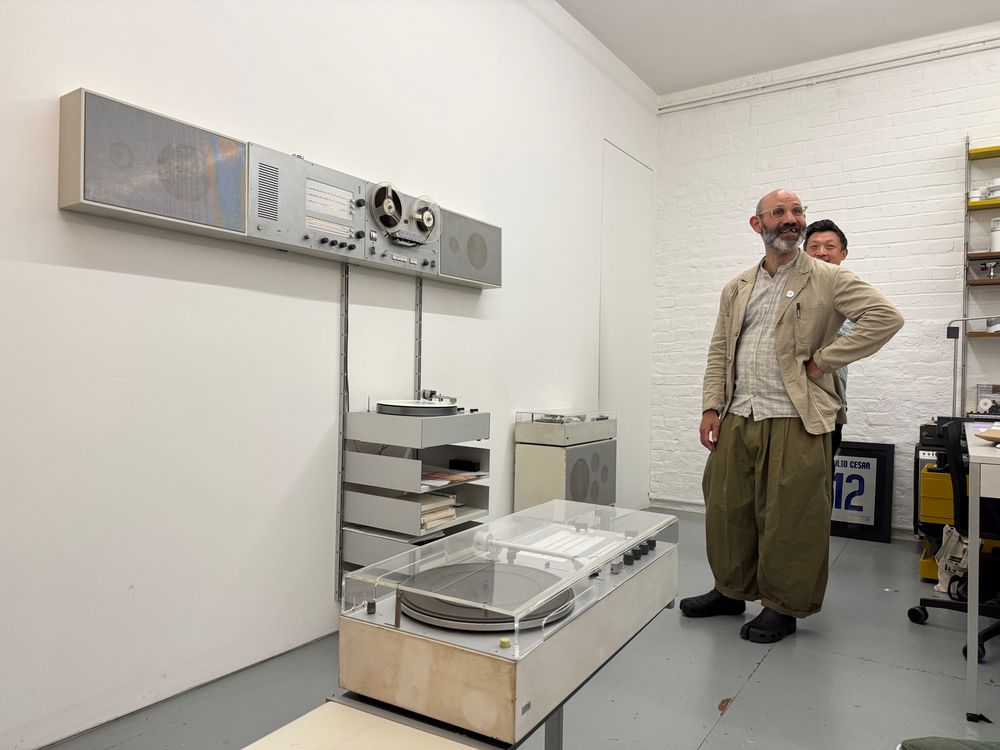 Dr Peter Kapos of Das Programm, demonstrating the Braun / Vitsoe wall system, playing Brian Eno.  L 450 Speakers / TS 45 Tape deck / PCS 52 E Turntable hung on Vitsoe E track, in custom lengths for speakers.