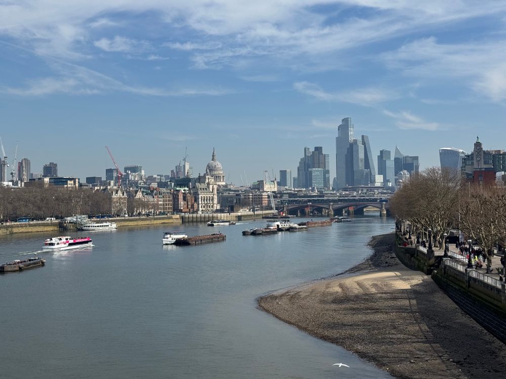 Thames low tide and City skyline in the sun 