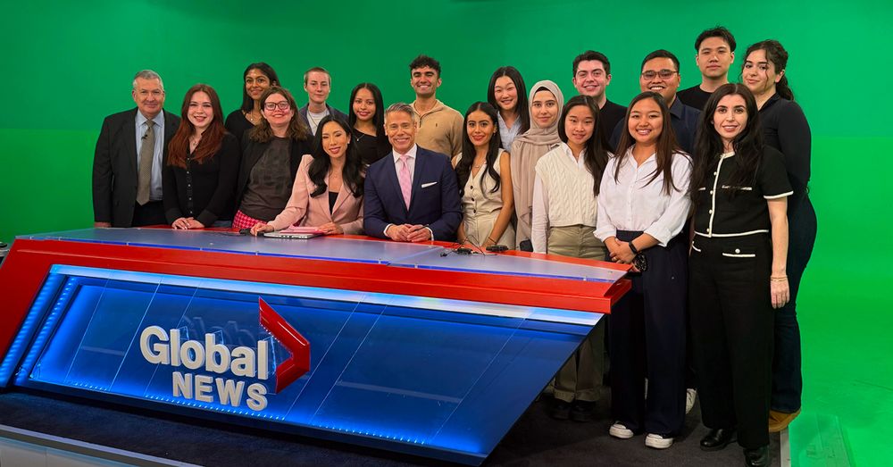 Professor Semra Sevi and her students standing behind a global news desk.