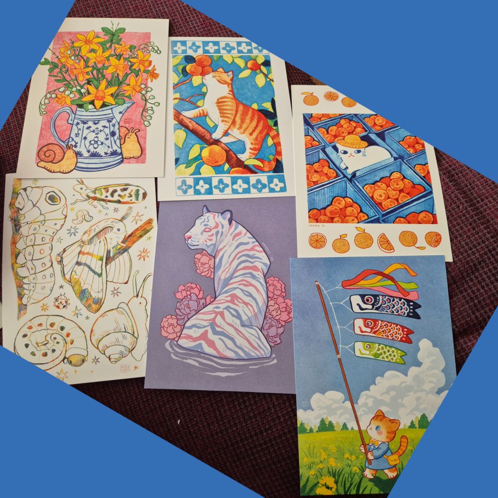 A photo of 6 prints of illustrations. Some mainly colored pencil, some digital art. 

First row (left to right): 
The first shows a flowers, mainly daffodils, in a jug. There are two snails next to the jug. 
The second shows an orange cat standing on a branch in between orange/yellow fruit and leaves. The background is blue and on the top and bottom is a blue and white pattern as a frame. 
The third has a small white cat with a straw hat in a blue box, surrounded by more blue boxes with oranges in them. There again is a frame on the top and bottom of the image, this time out of oranges. 

Second row (left to right):
Sketches of critters, moths/flying insects, caterpillars and a snail, all in rainbow colored pencil.

A white tiger with blue and pink stripes (in trans colors) sitting in water with flowers behind it. 

A cat holding a flag pole with fish flags and colorful ribbons that dance in the wind. The cat walks over a green field
