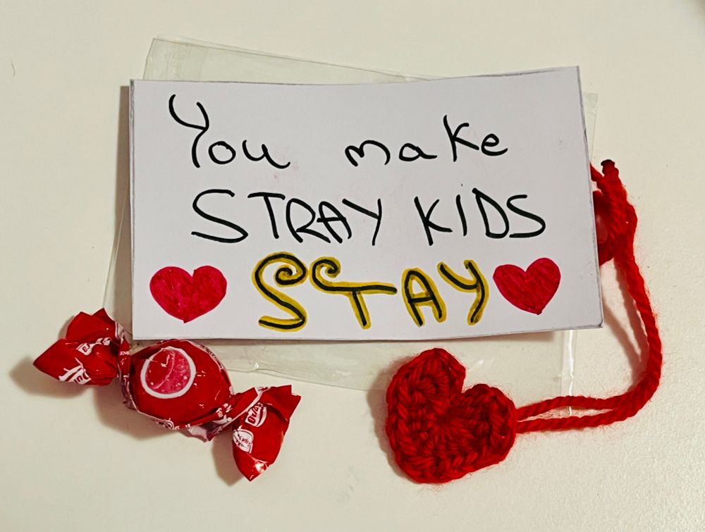 The photo shows a crochet heart made by a fan and a card that says “You Make Stray Kids.”