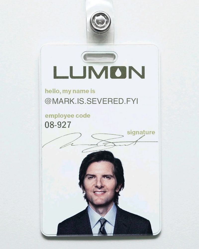 An edited version of Mark Scout's Lumon badge showing an example `@mark.is.severed.fyi` handle in the name field.