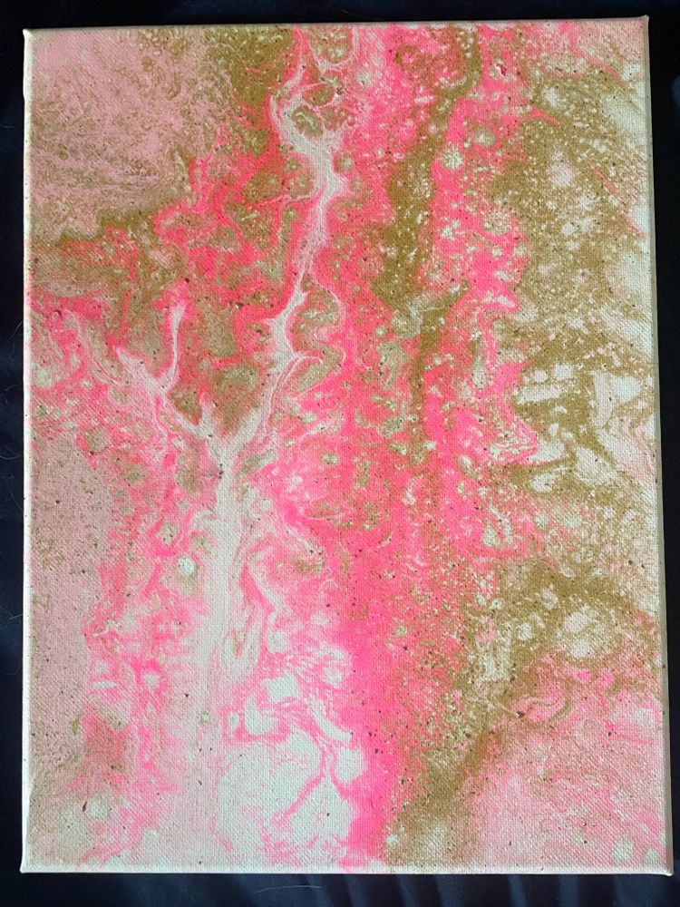 A pour painting in gold, white, and two tones of pink paint. A large white patch flows through the pink and gold paint on the left side of the canvas. Acrylic on canvas. 