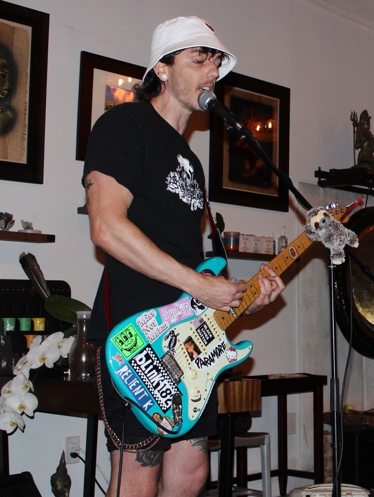 Kasey playing guitar + singing during rehearsal 