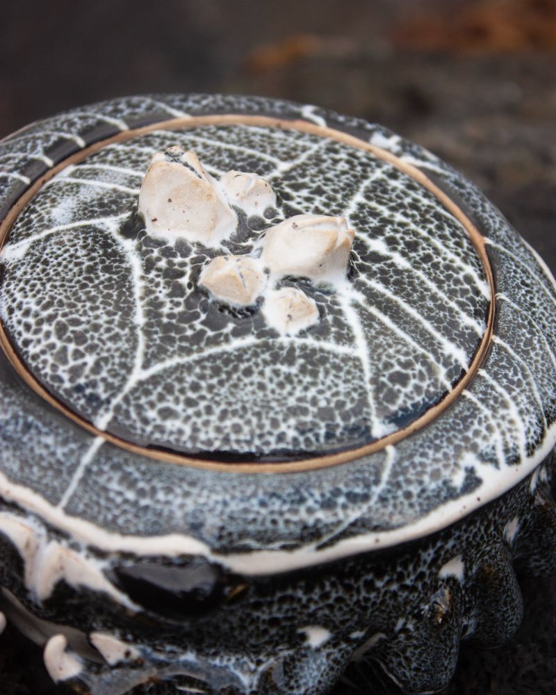 Close-up top down view of ceramic Hawaii Aʻama crab showing line patterns and glazing detail. Little barnacles were sculpted on the lid to act as a handle