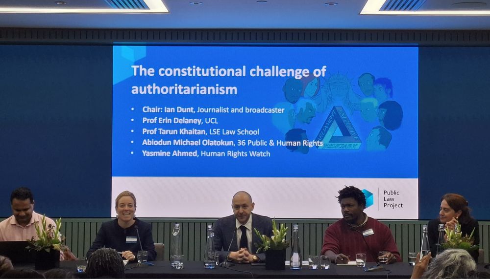 Panel assembled on the podium in front of the room, sitting in front of a slide. Title of the session: The constitutional challenge of authoritarianism. Chair: Ian Dunt, Journalist and broadcaster. 
Speakers: Professor Tarun Khaitan, LSE Law School, Professor Erin Delaney, Leverhulme Professor & Director, UCL Global Centre for Democratic Constitutionalism,  Abiodun Michael Olatokun, 36 Public & Human Rights, Yasmine Ahmed, Human Rights Watch