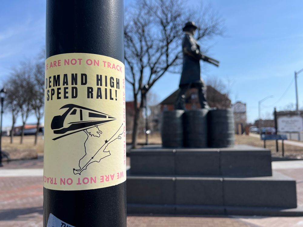 Sticker on the street demanding high speed rail reach Windsor. 