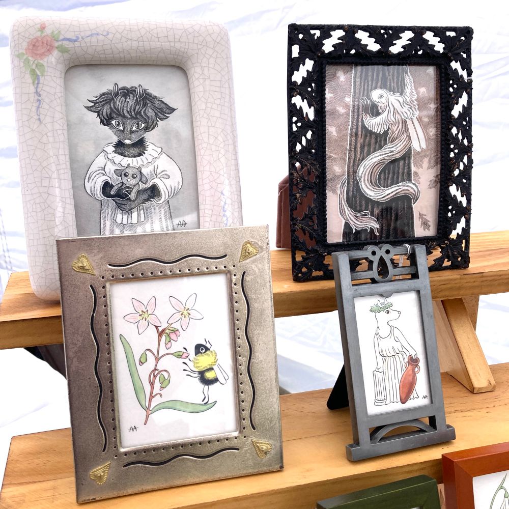 A photograph of four strange illustrations in unique vintage-style frames.