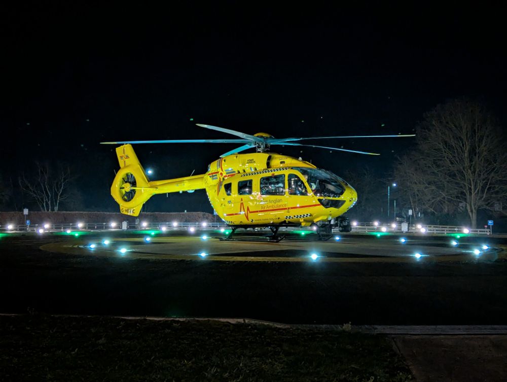 Yellow air ambulance helicopter on a lot hospital helipad on a dark evening
