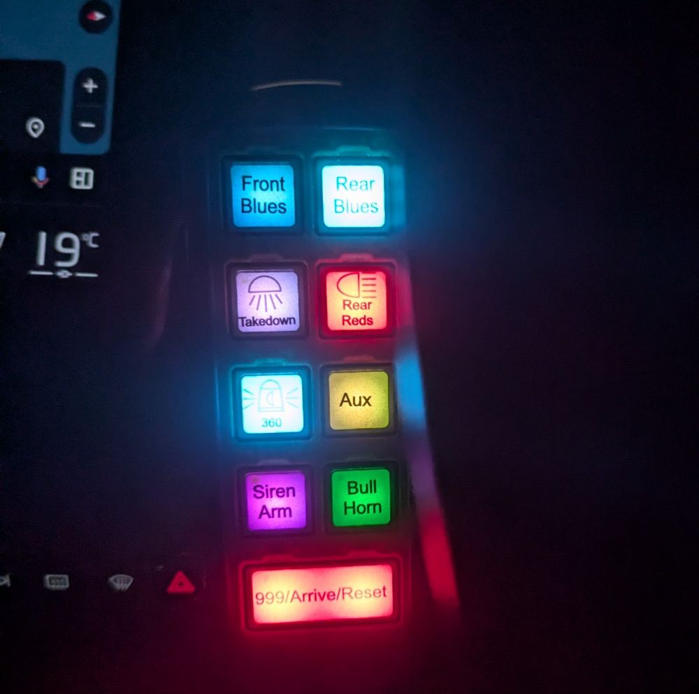 Emergency vehicle lighting control panel with 6 square switches and 1 rectangular switch - all lit in different colours