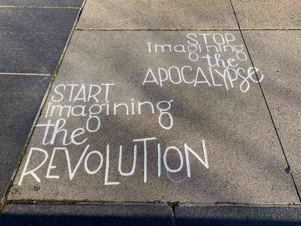 Stone floor with writing: Stop imagining the apocalypse. Start imagining the revolution.