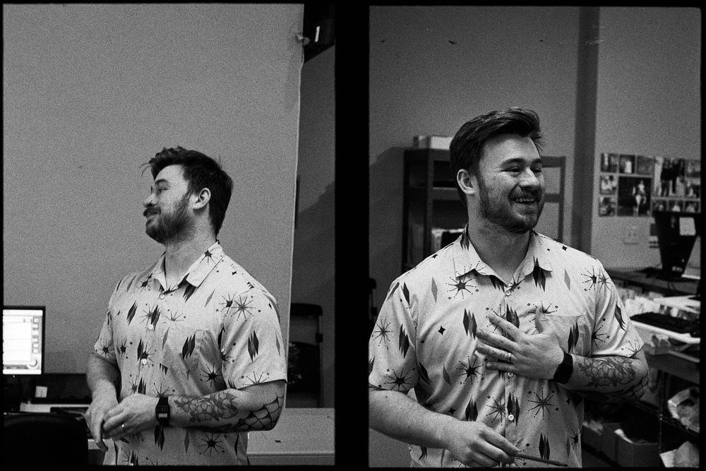 Black and white diptych of a man smiling and looking off camera, in one photo he’s got his hand on his chest.