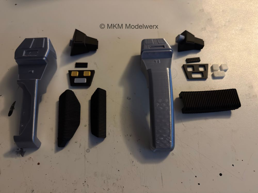 Two unassembled phasers with their parts spread out. 
