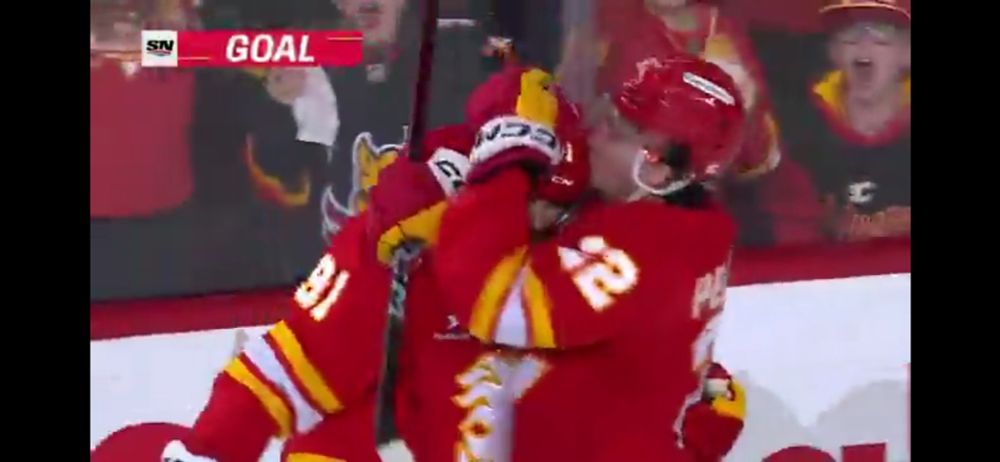 Picture of Calgary Flames player Jakob Pelletier kissing his teammate Nazem Kadri's helmet 