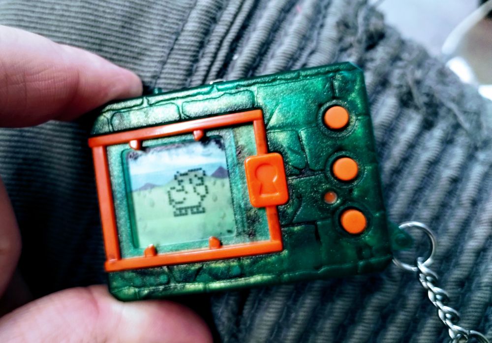 Biyomon sprite on the lit up display of a green and orange Digital Monster 20th I have chained to my hip