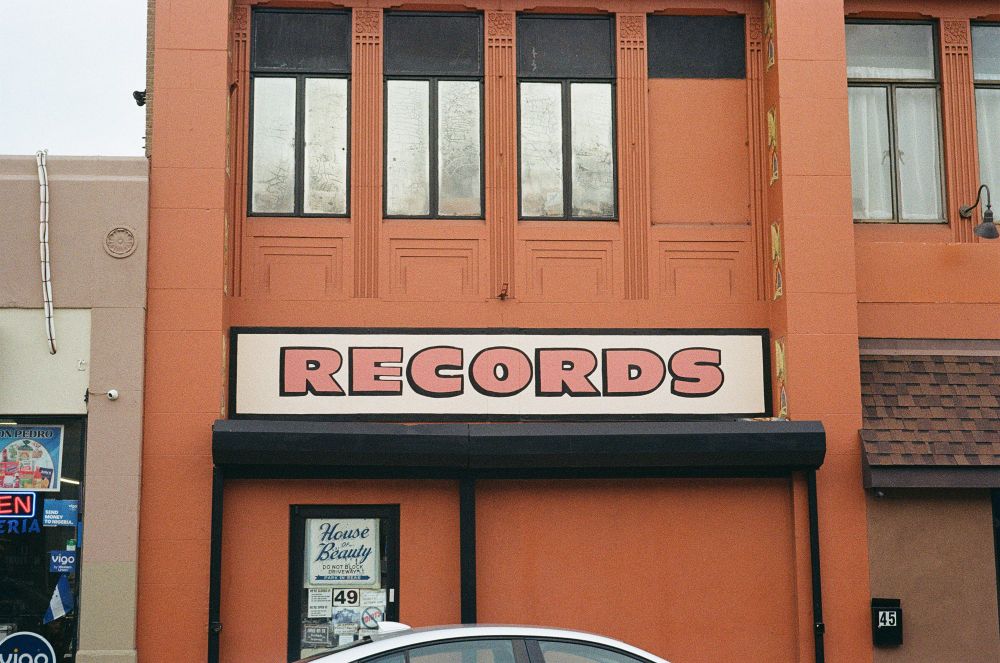 An old painted sign that reads records painted in the side of a building.