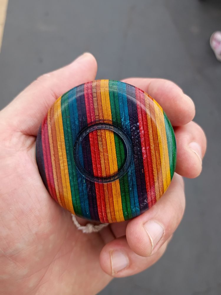 A yoyo made of rainbow striped laminated wood