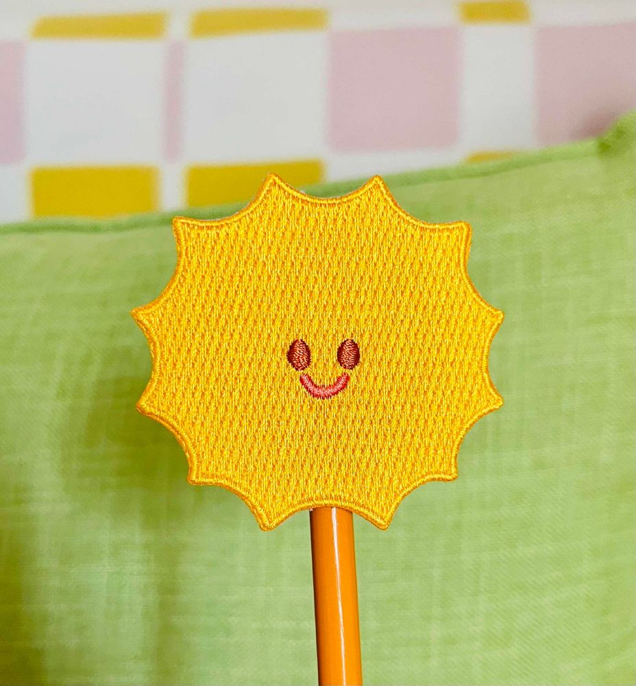 an embroidered patch of a smiling sunshine. 