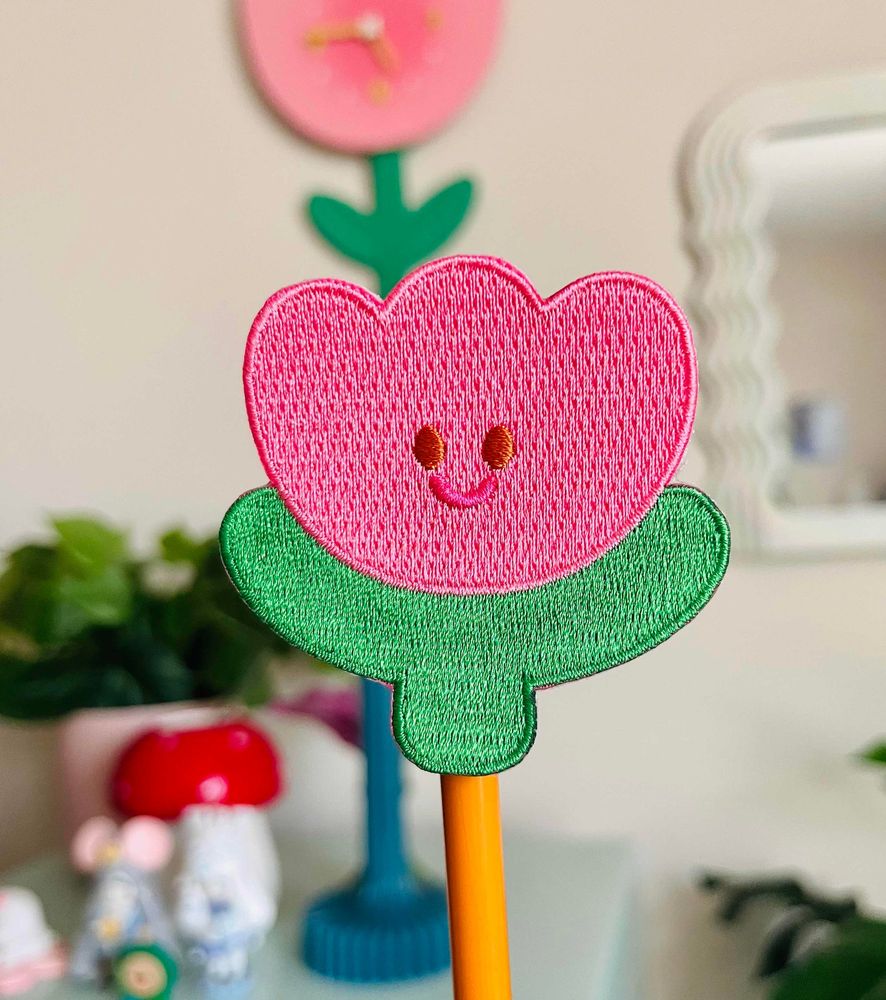 an embroidered patch of a smiling tulip.
