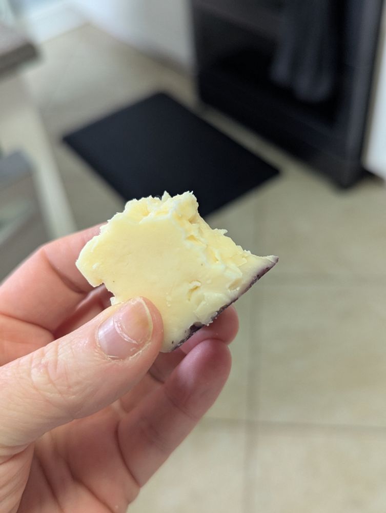 A chunk of trader Joe's syrah cheese with bites nibbled off the edges. 