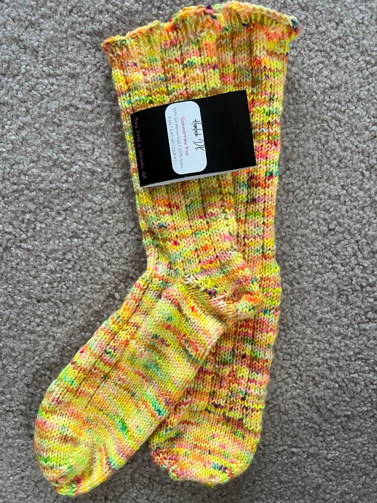 Pair of hand knit yellow with bright speckled socks. 