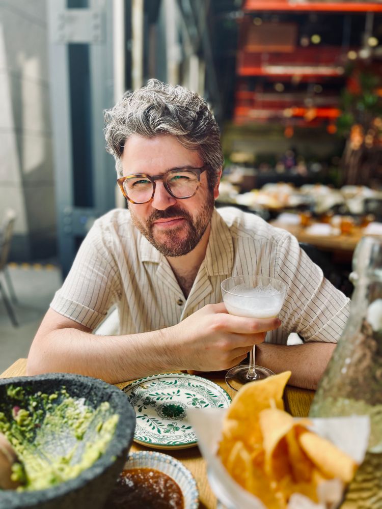 Me sitting with a margarita and chips and guacamole laughing