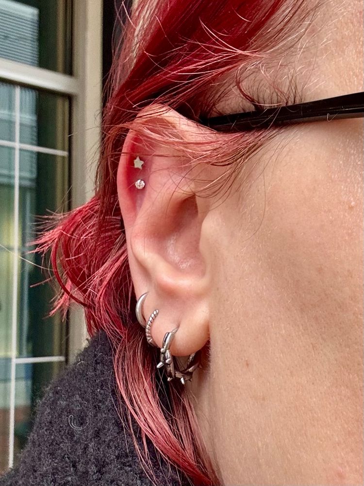 My ear against my dyed red hair. I have three lobe piercings and two new helix piercings.