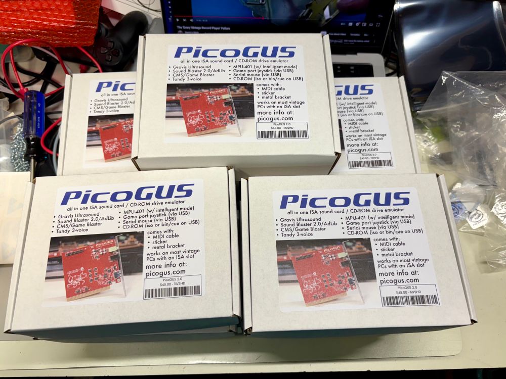 A stack of boxes with Picogeese inside. They have a sticker on top describing the product