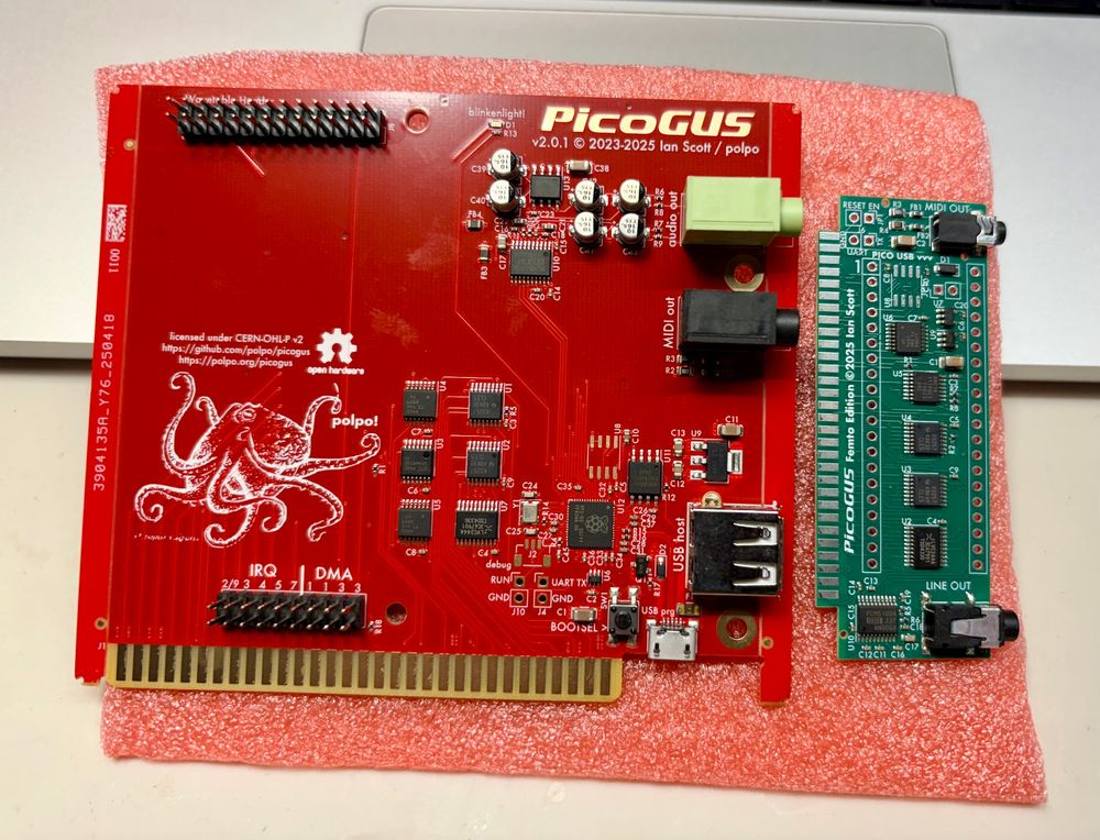 Two PCBs, one larger and red, and one smaller and green. The red one is a regular PicoGUS board and the green one is the Femto version.