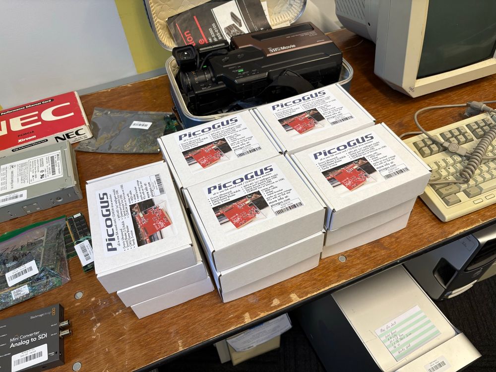 A stack of boxes on a table with PicoGUS labels on them