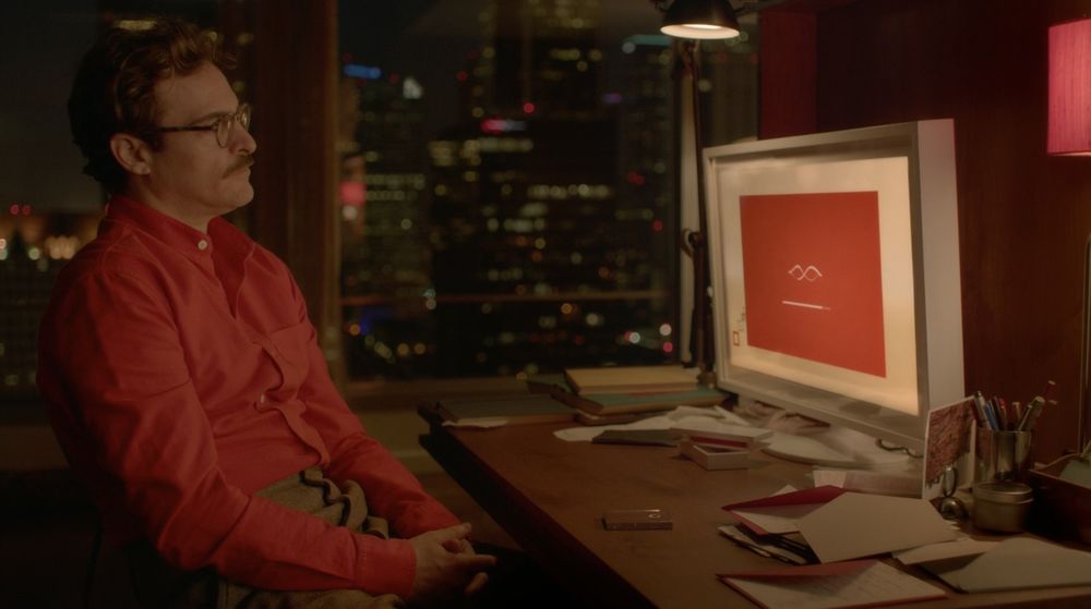 An image of a man looking at a computer screen from the movie Her (2013), a film about a man who falls in love with an AI