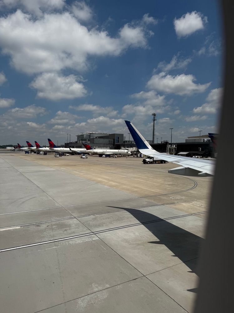 Tarmac of  Hartsfield-Jackson International Airport, viewed from the window of a plane. There are several parked planes visible from the window