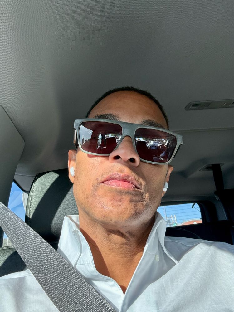 Don in sunglasses wearing AirPods & a seatbelt in the back of an SUV 