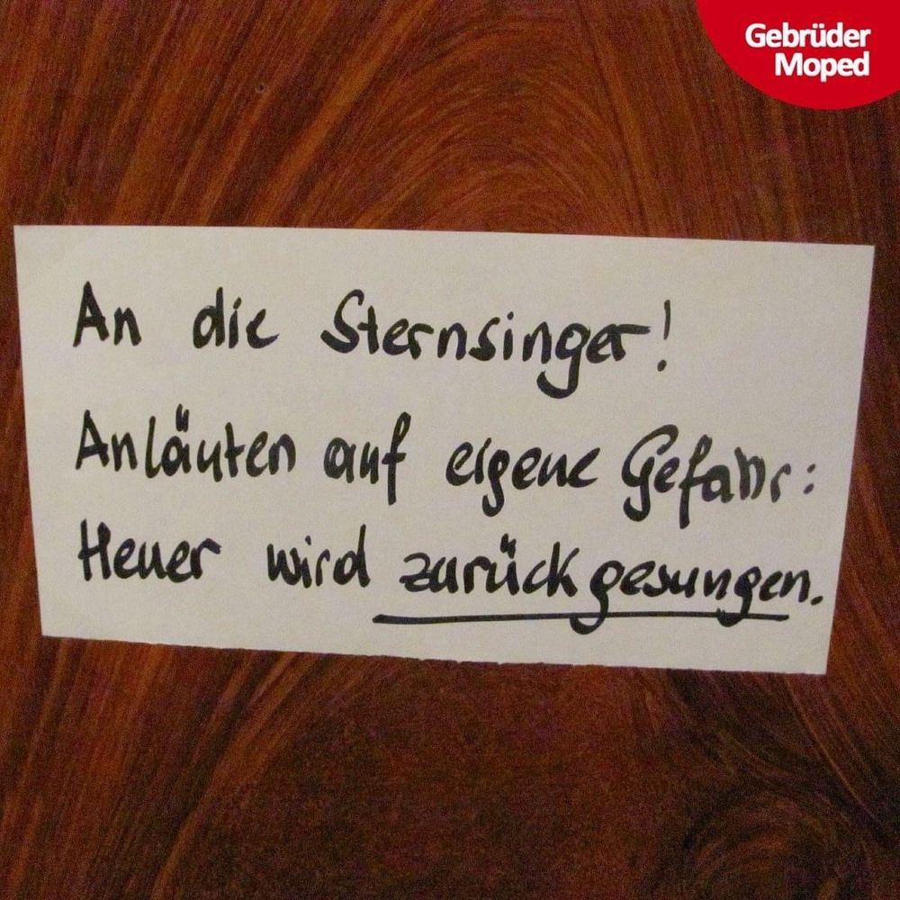 Zettel auf Holztür geklebt. Darauf steht mit Hand geschrieben: „An die Sternsinger! Anläuten auf eigene Gefahr: Heuer wird zurückgesungen.“