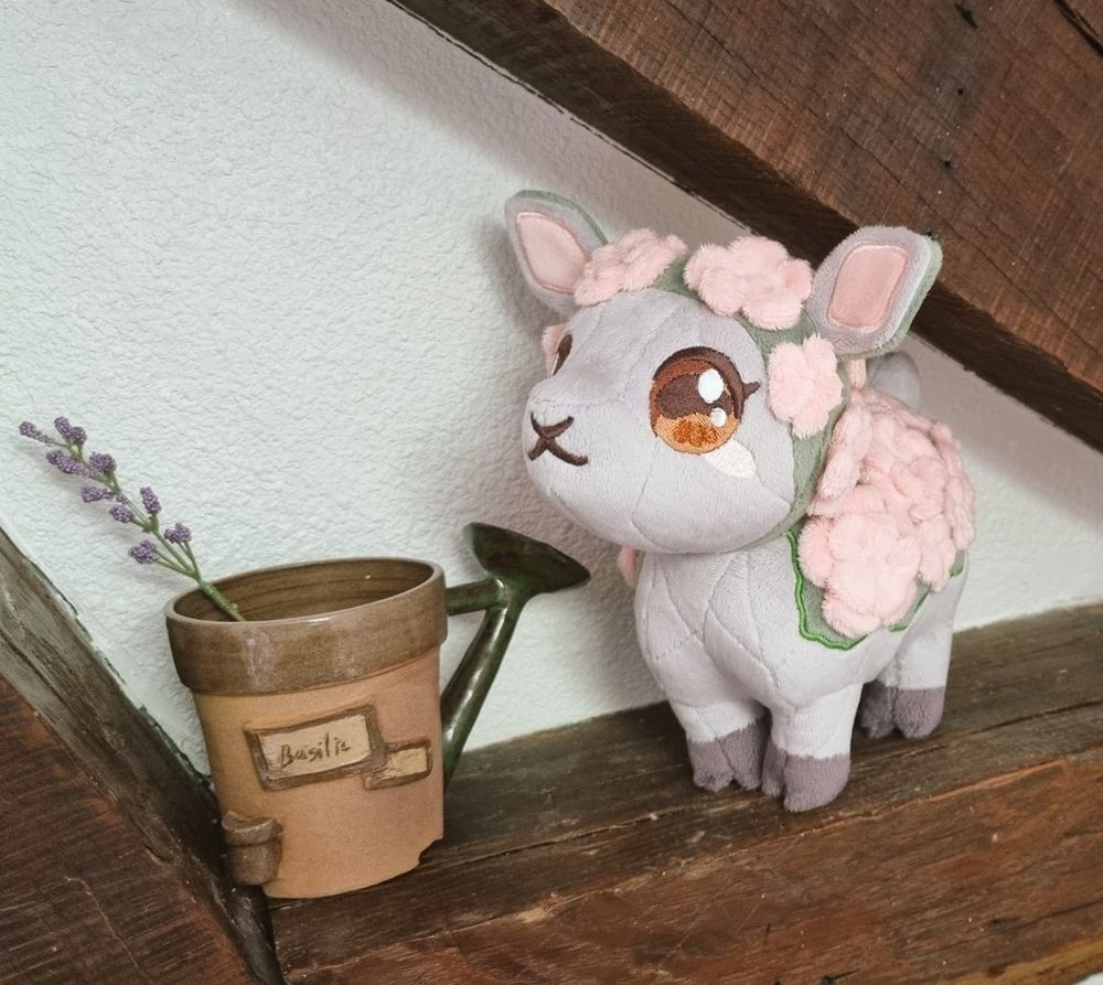 Peluche inspirée de Rosie de World of Warcraft. C'est un mouton en pierre recouvert de mousse avec des fleurs sur le dos.
