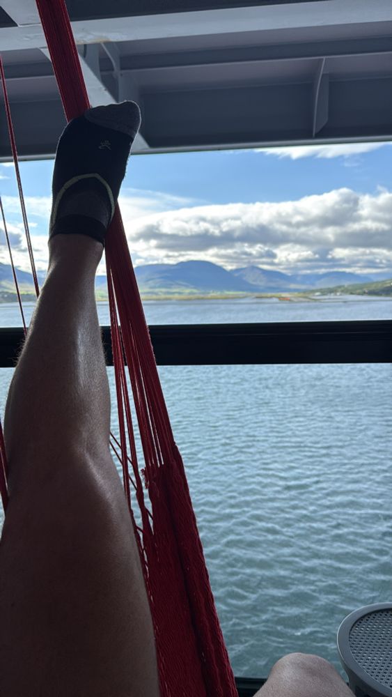 Elevated sore leg on a hammock looking at an Icelandic airport runway from the water. 