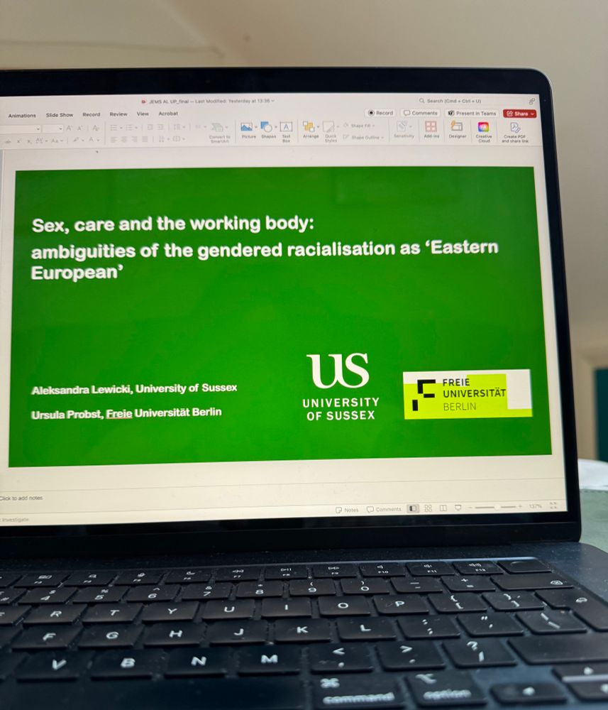 The image shows a laptop with the opening slide of the presentation 