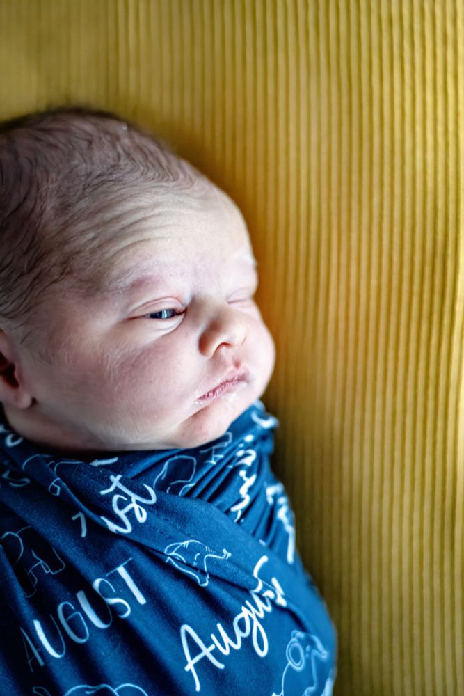 Newborn baby with one eye open. Kayza and Vine Creative Co. Iowa Photographer 2024