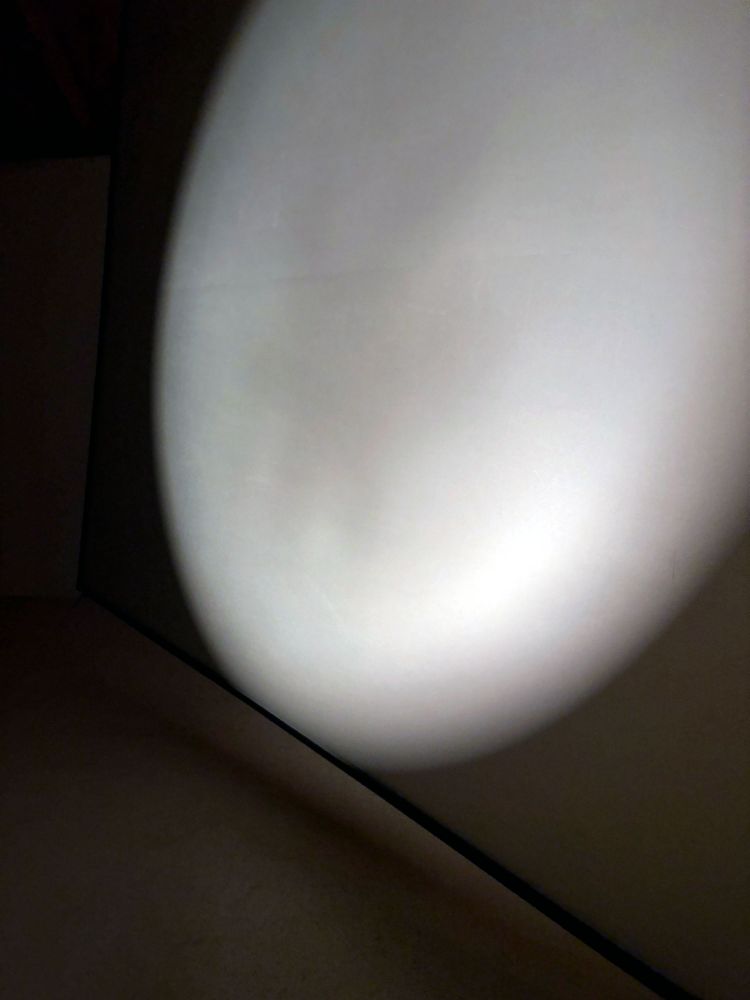 Close up of a large format screen with a circle of light projected in it.
