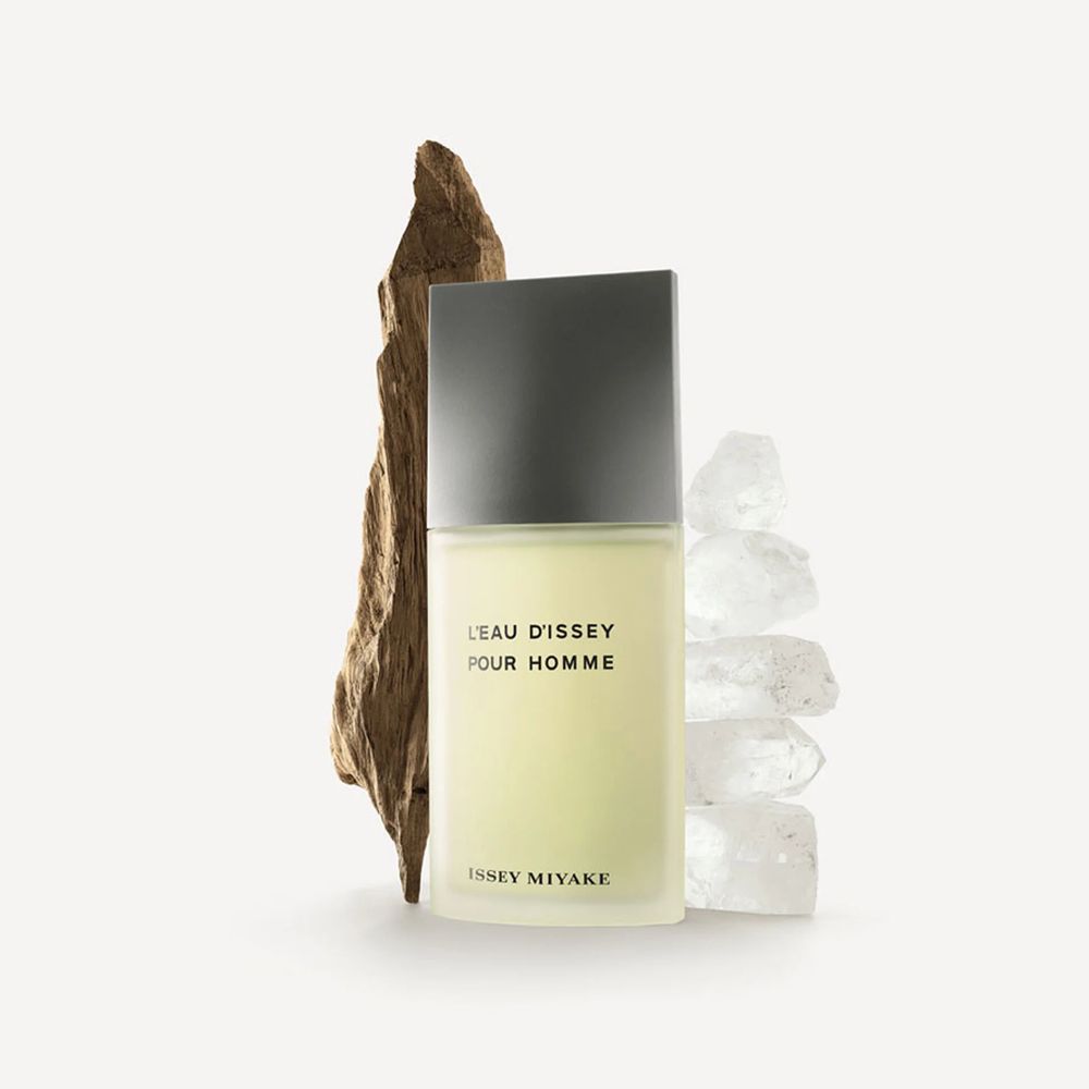 A bottle of Issey Miyake Pour Homme in front of what looks like driftwood and ice.