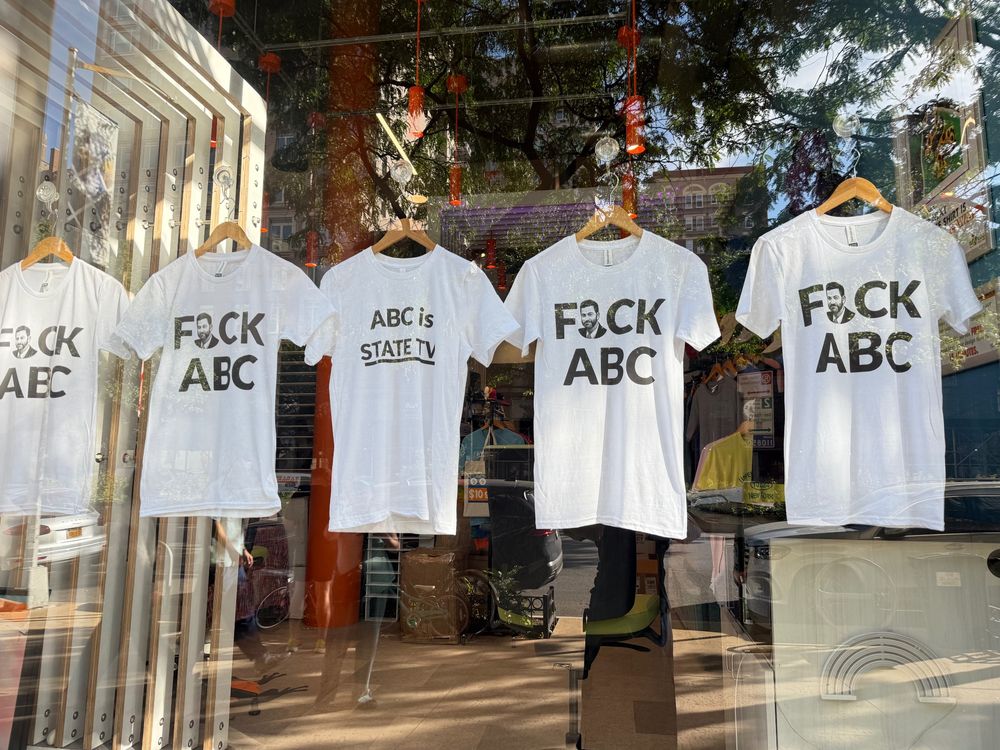 A window full of "FUCK ABC" T-shirts, and one reading "ABC is State TV." Kimmel's face substitutes for the "U."