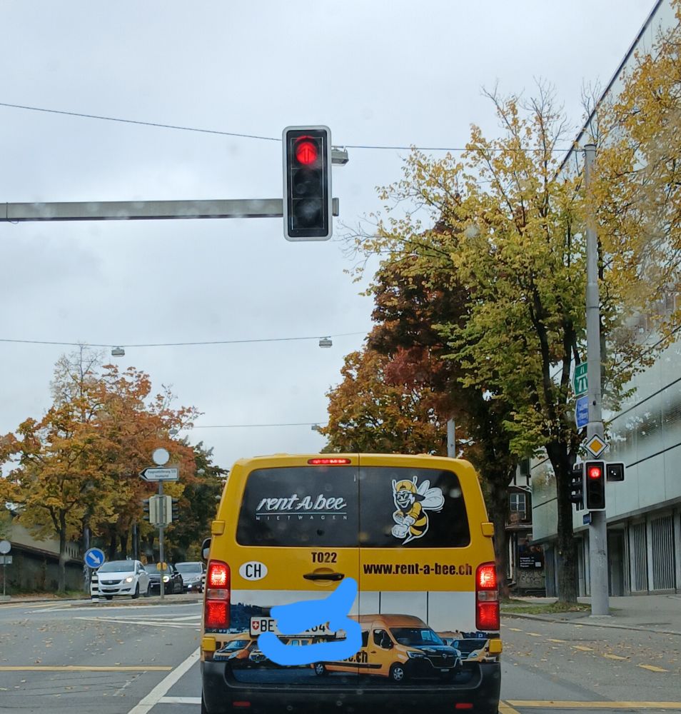 Gelber Mietwagen Van, rote Ampel, Bäume in Herbstfarben 