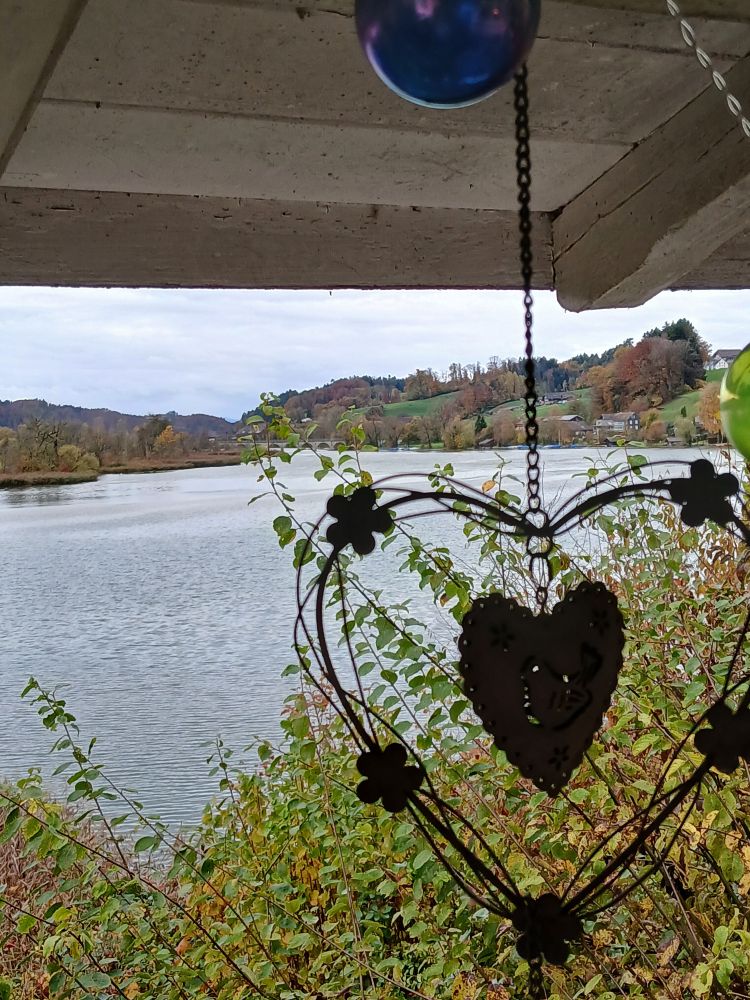 Metallherz vor regnerischem Himmel und See 