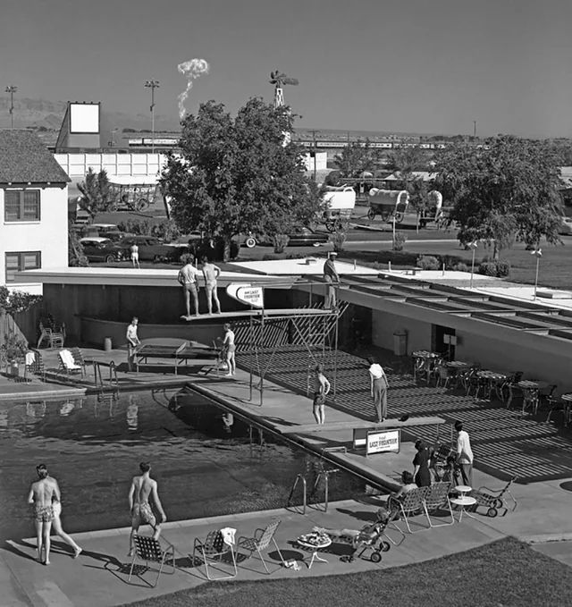 A group of people in swimsuits watch the mushroom cloud from an atomic test in the Nevada Test Site from their hotel swimming pool in Las Vegas in May 1953.